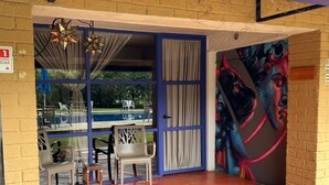 A room with a pool view, a mural, and a sign indicating a location. - Hospedaje Los Cruxes Tepoztlan (Tepoztlán)