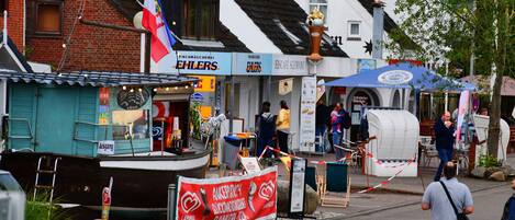 A street scene with a boat, a flag, and a signboard.