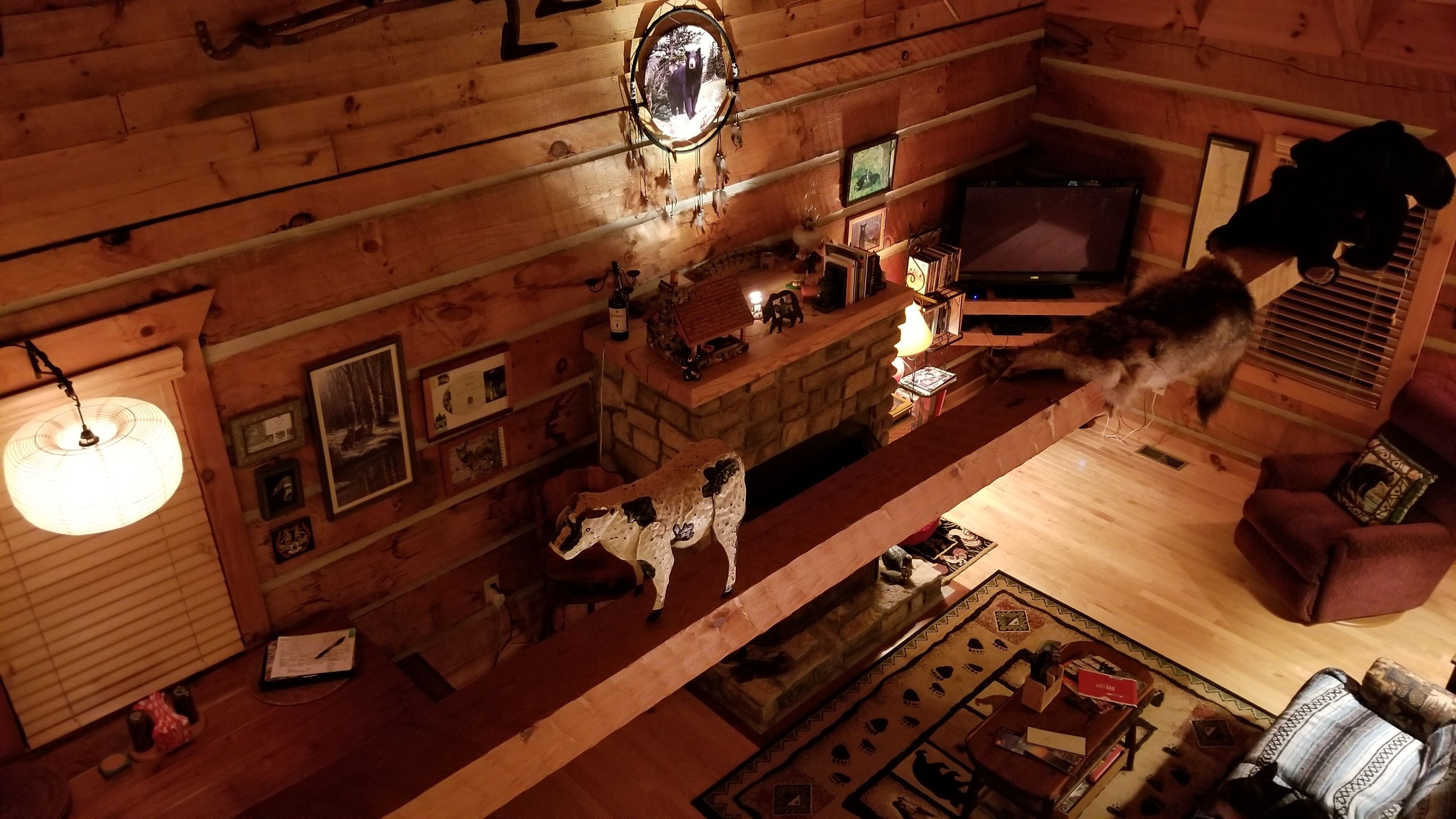 Een gezellig cabin interieur met houten wanden, een open haard, een televisie en een hond.