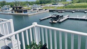 Una marina con barche ormeggiate, un piccolo edificio e un'area verde recintata sullo sfondo.