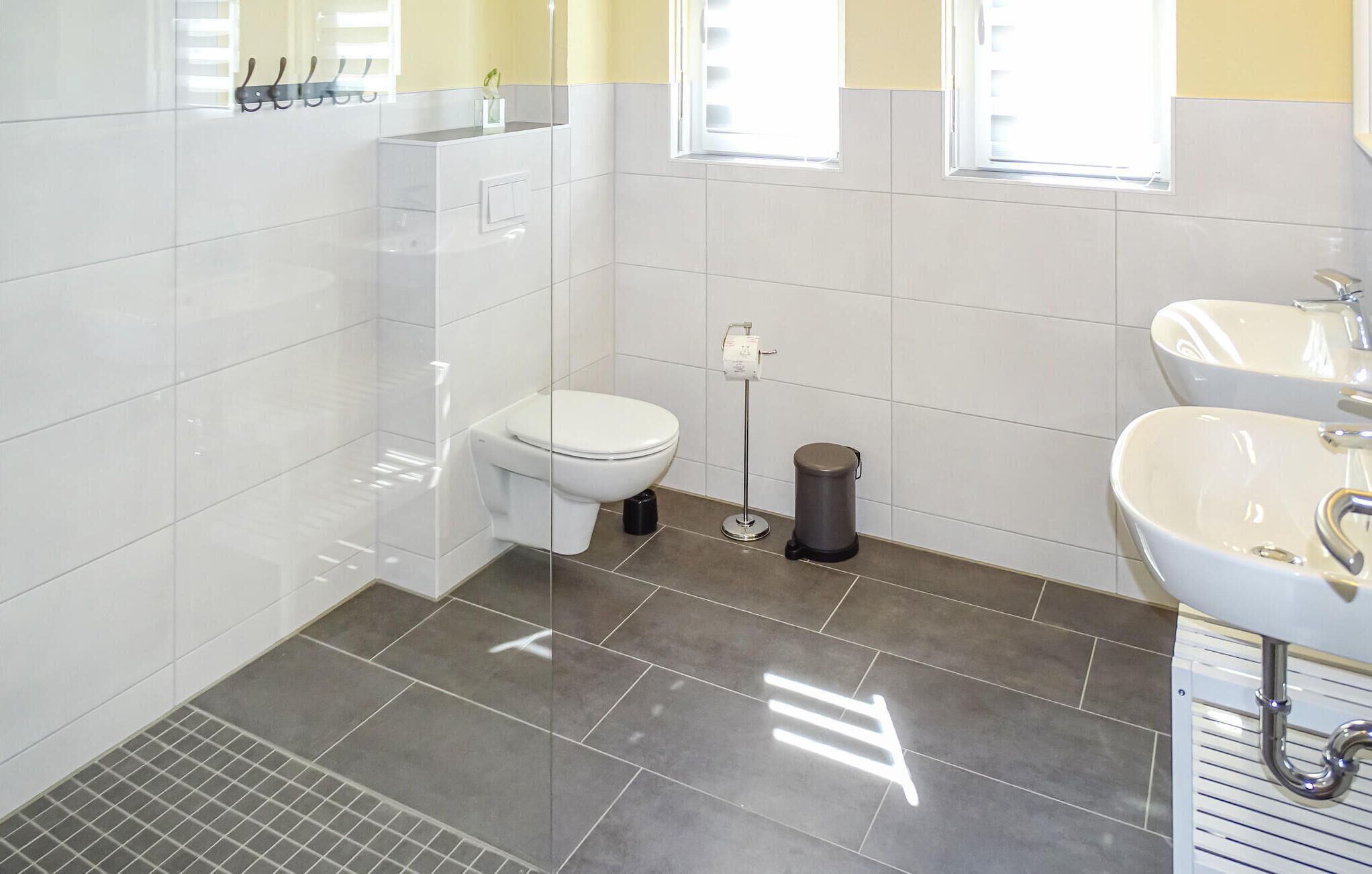 Ein modernes Badezimmer mit Toilette, Bidet und Waschbecken.