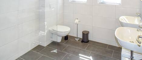 Ein modernes Badezimmer mit Toilette, Bidet und Waschbecken.