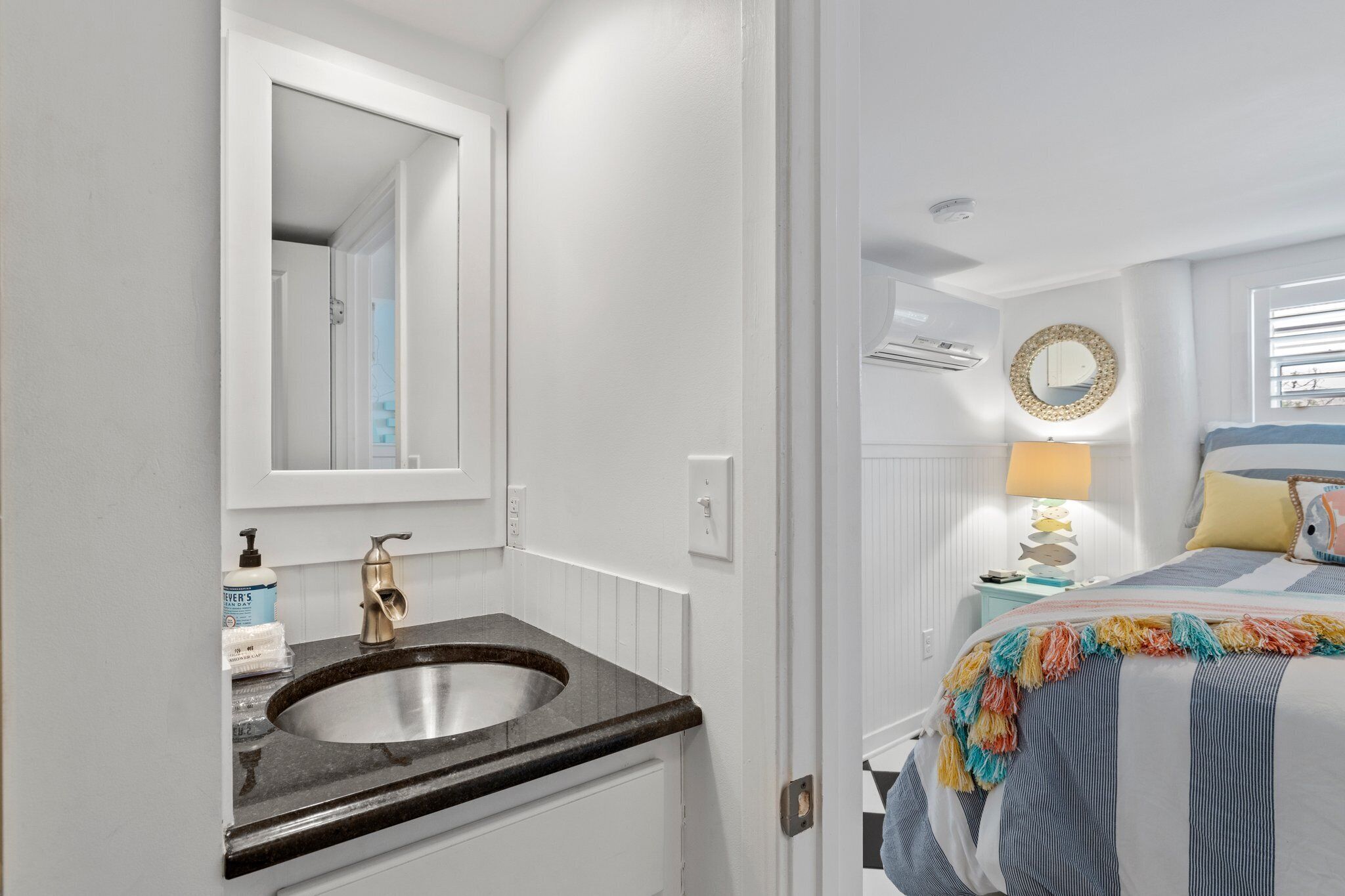 A bathroom with a sink, mirror, and toiletries.
