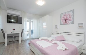 A modern bedroom with a bed, a desk, and a TV. - Beautiful apartment in Podaca with WiFi (Podaca)