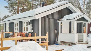 A cabin with a wooden deck and a covered porch, surrounded by snow. - 3 bedroom stunning home in Särna (Särna)