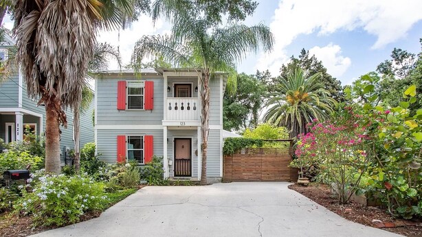 A two-story house with a front porch, a driveway, and a variety of plants and trees. - Luxurious indoor/outdoor Family Paradise in downtown St Augustine (St. Augustine)