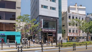 A modern hotel with a prominent 'U' logo, multiple floors, and a glass facade. - Staywell Hotel (Busan)