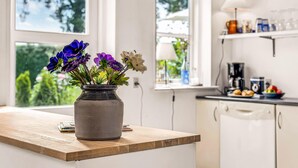 A kitchen with a wooden countertop, a vase with flowers, and a window with a view of greenery. - Gorgeous home in Sydals with WiFi (Sydals)