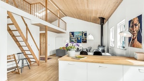 A modern loft with a wooden staircase, a kitchen area, and a dining space. - Gorgeous home in Sydals with WiFi (Sydals)