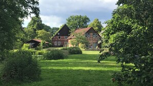 Un'ampia casa tradizionale con un prato curato e vegetazione circostante.