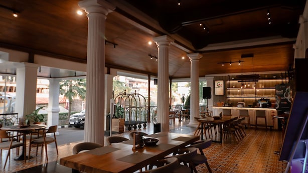 A spacious indoor area with high ceilings, large windows, and a mix of seating arrangements including tables and chairs. - FIM by Zigna (Surakarta)