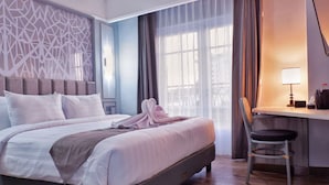 A hotel room with a bed, a desk, and a chair. - FIM by Zigna (Surakarta)