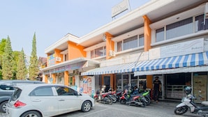 A multi-story building with a bakery on the ground floor, a pharmacy, and a restaurant. - Applewood B&B (Bogor)