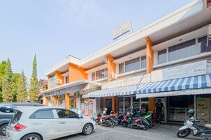 Un edificio de varios pisos con una panadería en la planta baja, una farmacia y un restaurante.