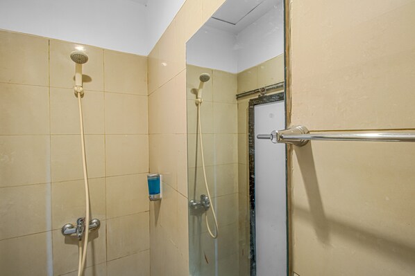 Un espacio de ducha con dos cabezales y una puerta de vidrio.