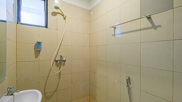 A bathroom with a sink, a shower, and a window.