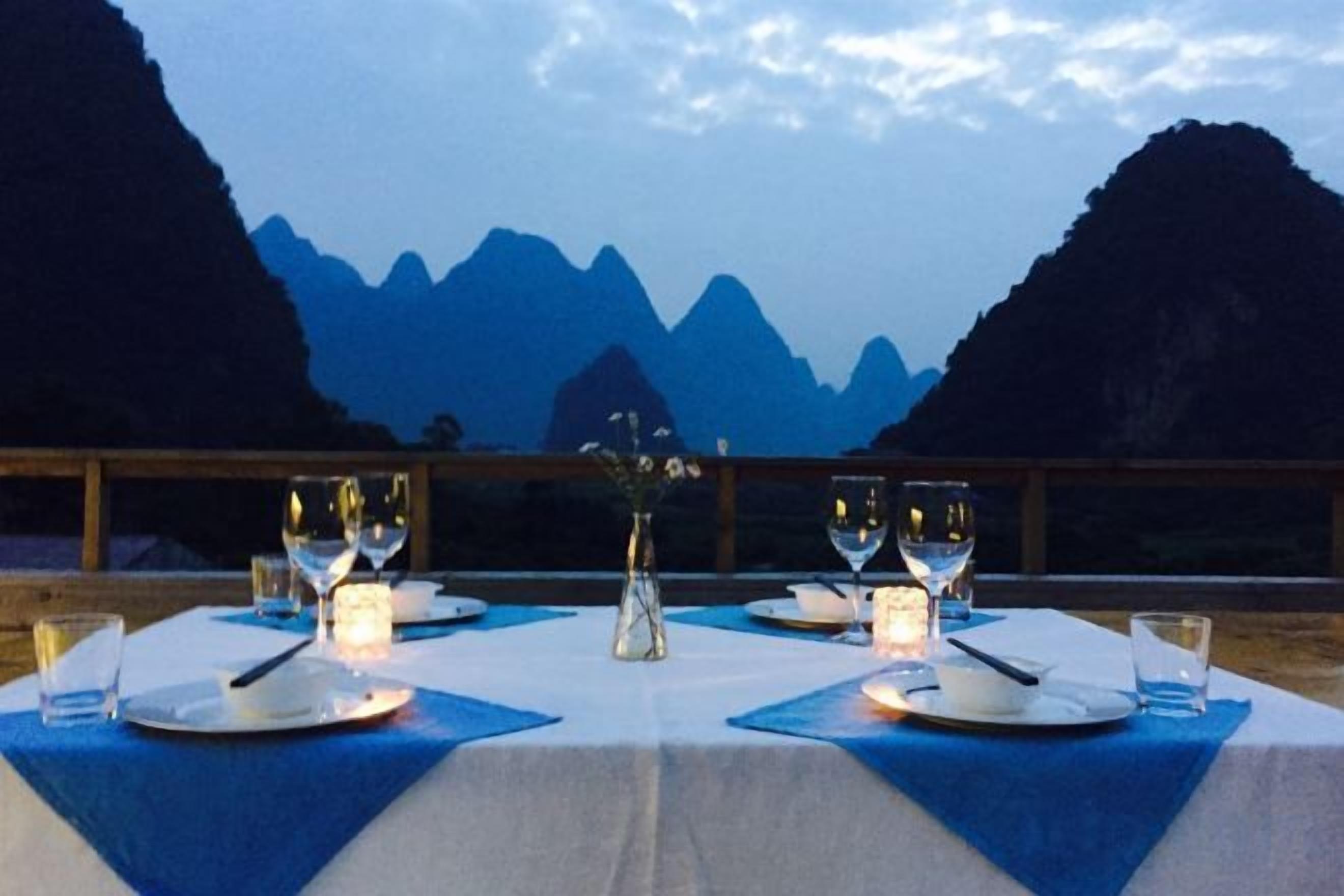 Mesa lista para comer con vista a la montaña al fondo.