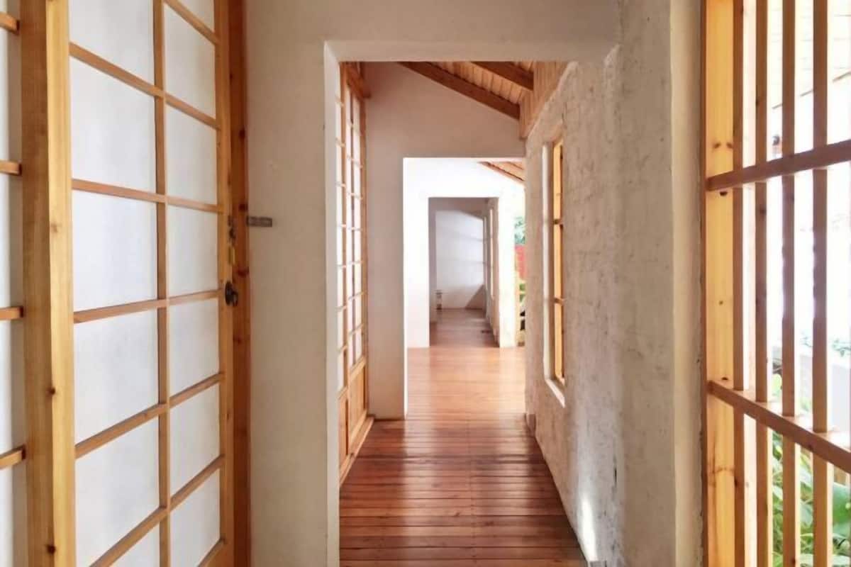 A corridor with wooden flooring and shoji screens on both sides.