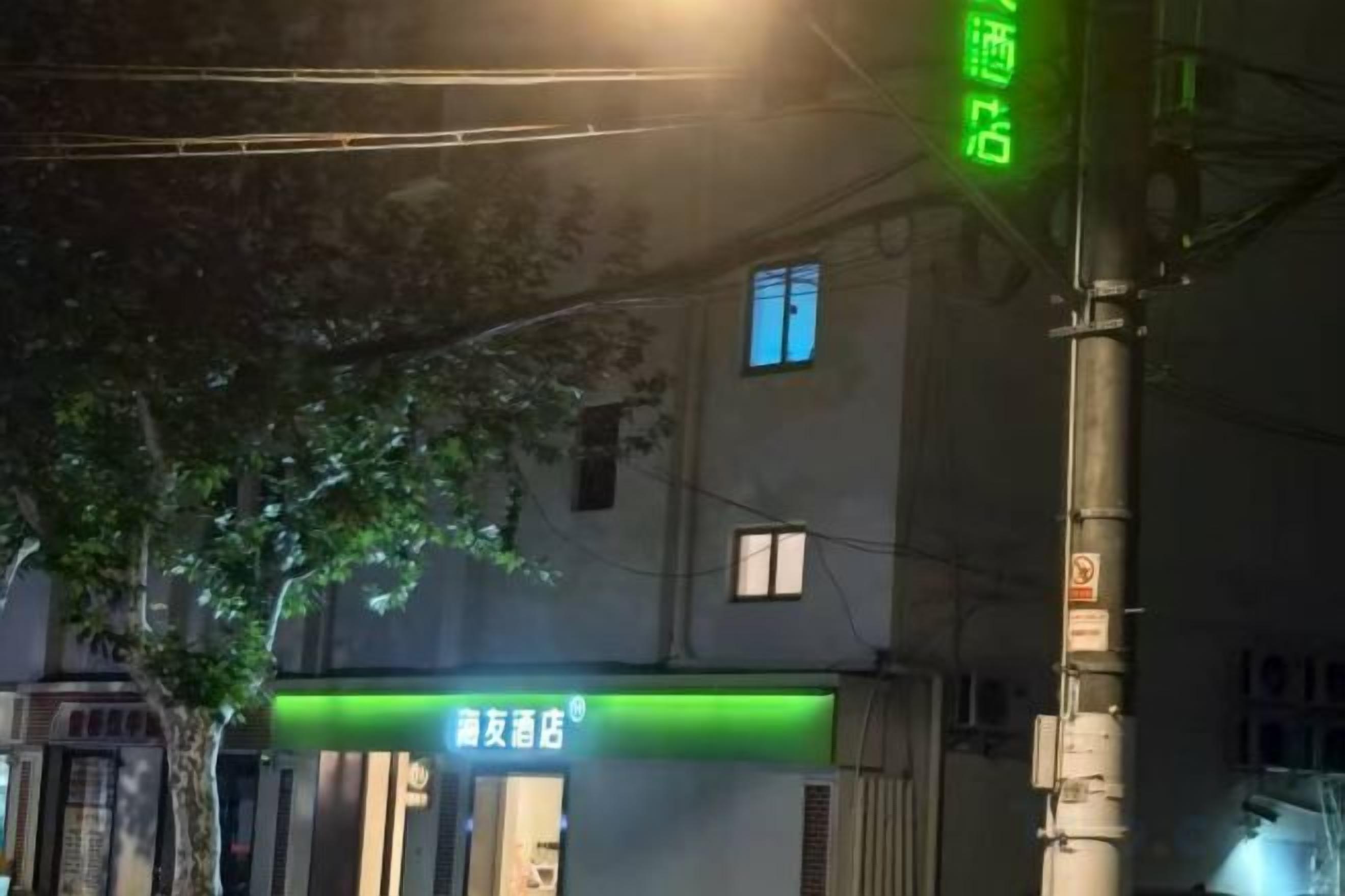 A building facade with a green sign indicating a business establishment.