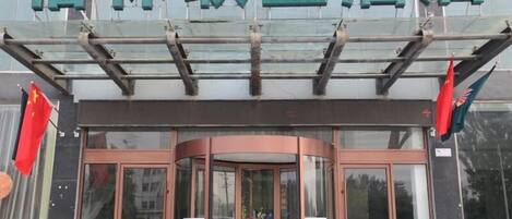 A hotel entrance with a glass door and a sign above.