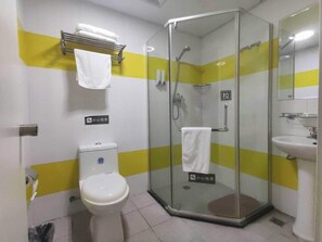 A bathroom with a glass-enclosed shower, a toilet, and a sink.