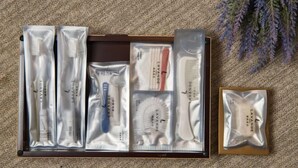 A neatly arranged set of personal care items in a wooden box, including tubes, brushes, and a comb, with a lavender plant in the background. - Lavande Hotel (Zhuanghe Xiangyang Road) (Zhuanghe)