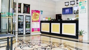 A hotel lobby with a reception desk, a digital screen, a clock, and a decorative floor pattern. - Greentree Alliance Gansu Longnan Beishan East Road Hotel (Longnan)