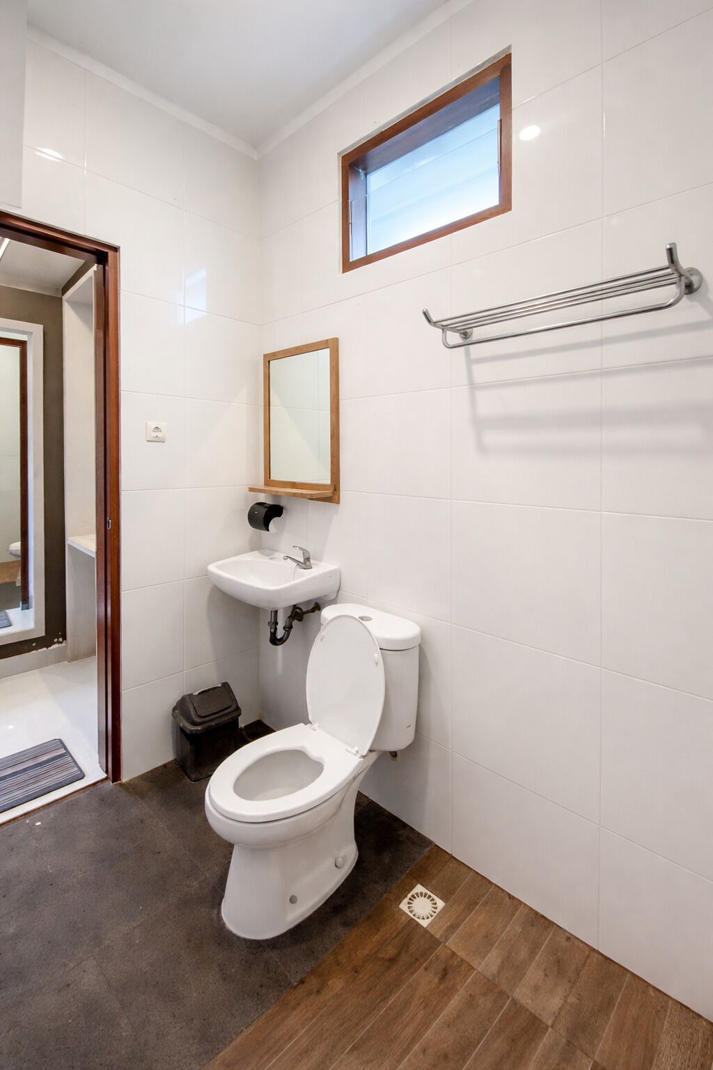 A bathroom with a toilet, sink, and mirror.