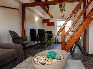 A modern interior with a staircase, seating area, and a view of the outdoors.
