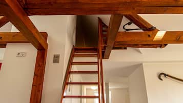 A wooden staircase with a handrail, a sign indicating a non-smoking area, and a door at the bottom.