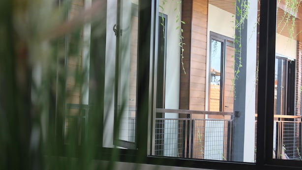 A view through a window with a metal railing, a wooden wall, and a door. - Amarilis near Sam Poo Kong (Semarang)