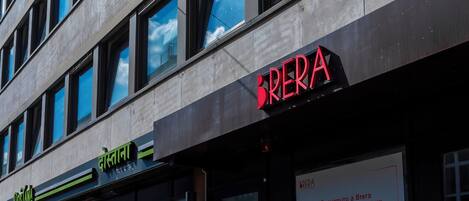 Ein Gebäude mit einer Schaufensterfront mit der Aufschrift 'BRERA' und einem Schild für 'Cafeteria'.