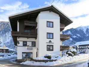 A multi-story building with a ski lift, a sign for a kitchen, and a view of snow-covered mountains.