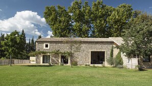 A stone house with a tiled roof, a front door, and a small window. - Dominique and Eric welcome you to their large, characterful Mas with heated swimming pool. (Verquiéres)