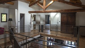 A spacious loft with exposed wooden beams, a mezzanine level, and a view of the surrounding area. - Dominique and Eric welcome you to their large, characterful Mas with heated swimming pool. (Verquiéres)