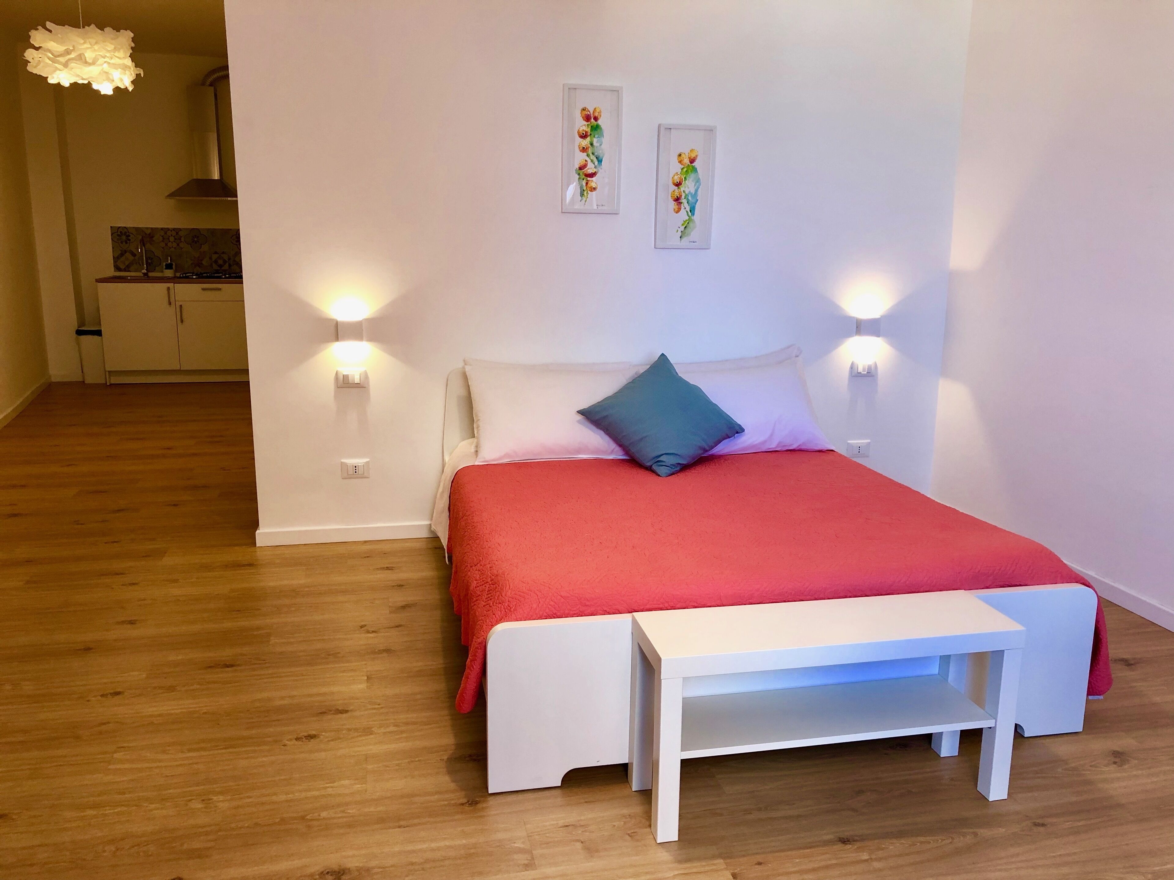 Een slaapkamer met een bed, nachtkastjes en wandlampen.
