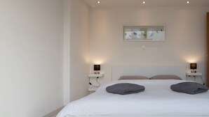 A modern bedroom with a large bed, two bedside tables, and a wall-mounted artwork. - Magnificent 76m² homm Penthouse 6th, Acropolis View (Athens)