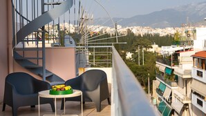A balcony with two chairs, a small table, and a spiral staircase. - Magnificent 76m² homm Penthouse 6th, Acropolis View (Athens)