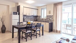 A compact kitchen with a dining area, a microwave, a refrigerator, and a tiled backsplash. - Magnificent 101m² homm Apartment, 4th (Athens)