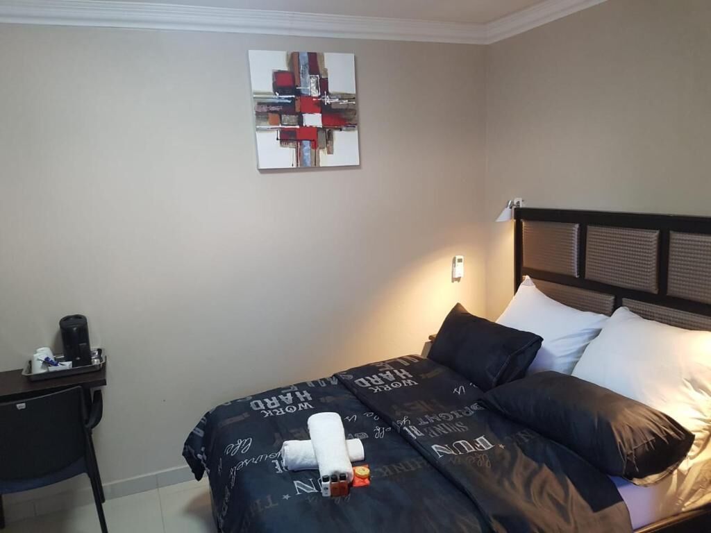 Quarto de hotel com uma cama, uma mesa e uma cadeira.