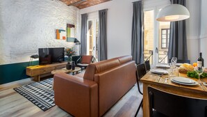 A modern living room with a sofa, dining table, and TV. - Comfortable apartment recently renovated and in the city center (Barcelona)