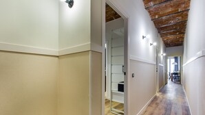 A hallway with wooden flooring, white walls, and a ceiling with exposed beams. - Comfortable apartment recently renovated and in the city center (Barcelona)