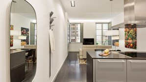 A modern kitchen with a dining area, a large mirror, and artwork on the walls. - Modern and comfortable apartment in the heart of the city (Barcelona)