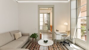 Una sala moderna con un sofá, una mesa de centro y una zona de comedor con una silla y una mesa.