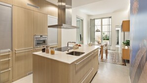 Una cocina moderna con electrodomésticos de acero inoxidable, armarios de madera y una isla central.