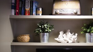 A bookshelf with books, a radio, and decorative items. - Urban Oasis homm Studio on Syntagma (Athens)