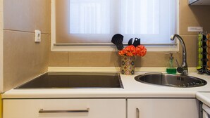 A kitchen with a window, a sink, and a vase with flowers. - Urban Oasis homm Studio on Syntagma (Athens)