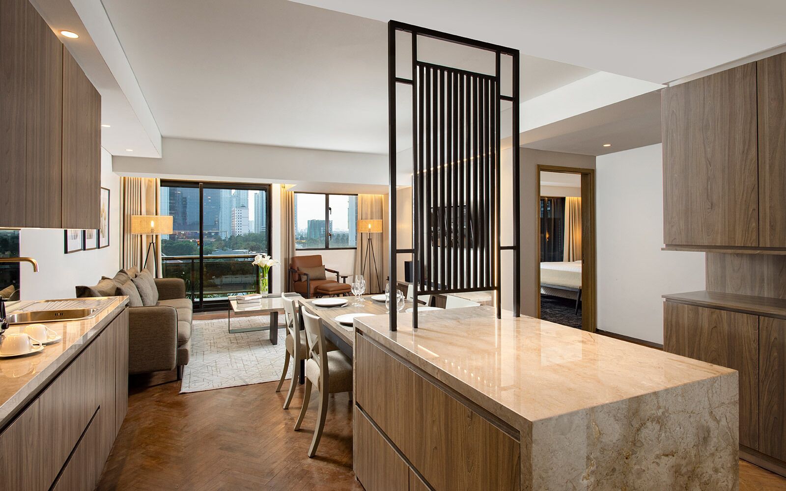 A modern kitchen with a central island, dining area, and a view of the city.