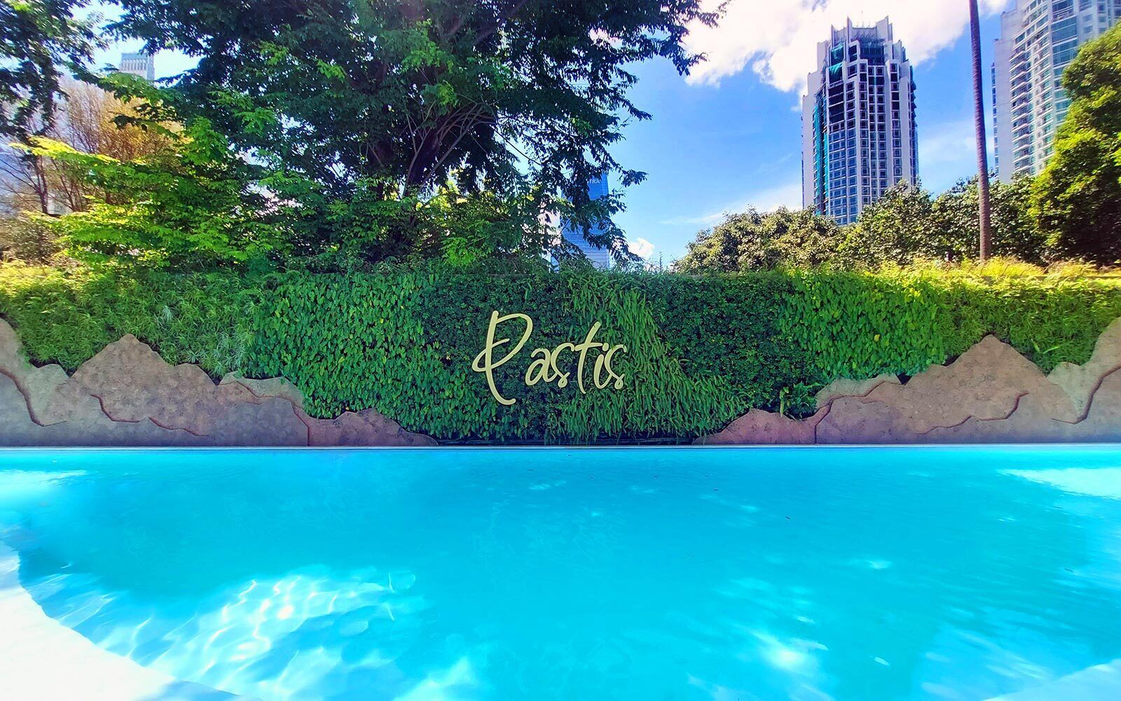 A swimming pool with a hedge and the word 'Rastis' on it.
