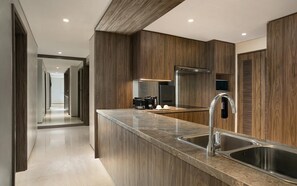 A modern kitchen with a central island, stainless steel sinks, and wooden cabinetry. - Oakwood Suites Kuningan Jakarta (Jakarta)